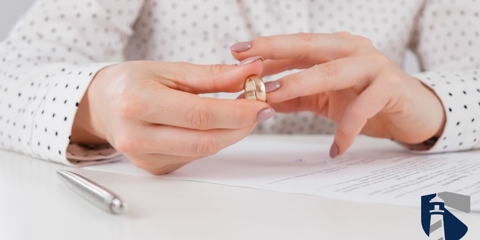 Woman signing bankruptcy papers while taking off her wedding ring